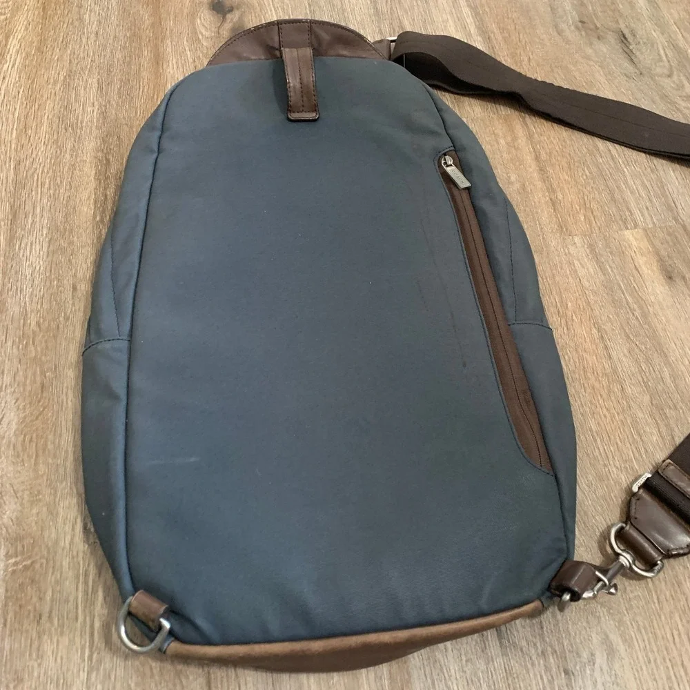 Coach 2013 canvas sling backpack in navy blue w/ brown leather panels - 13x18in‎